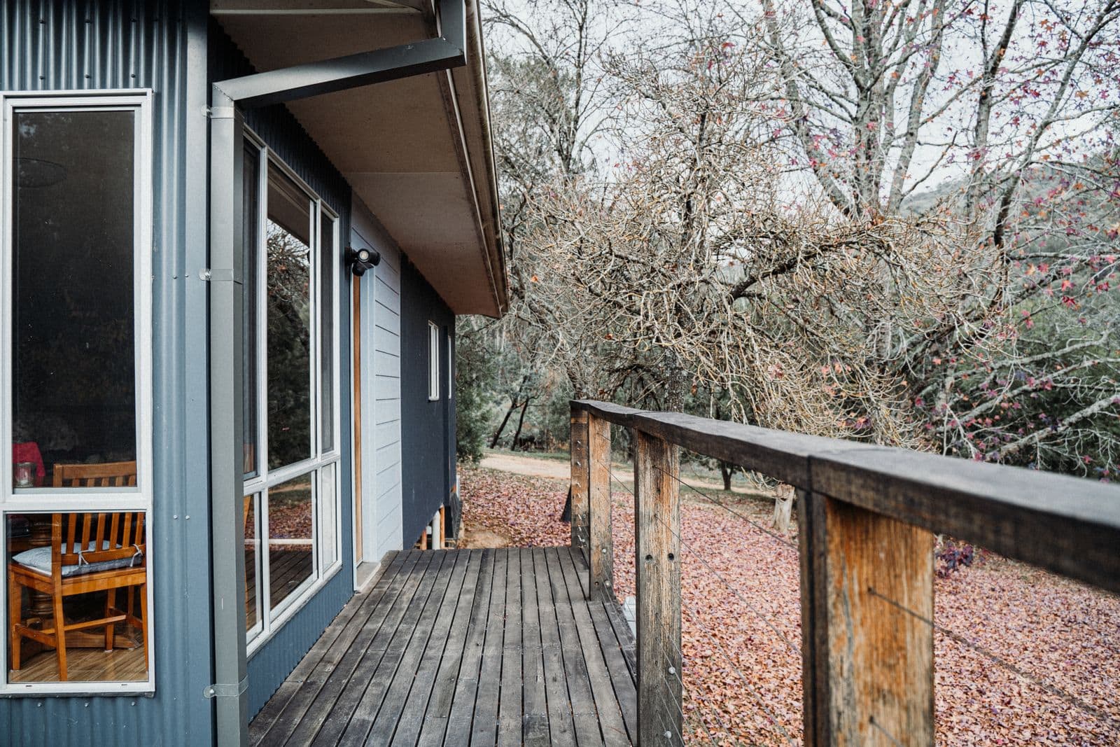 Deck running along the side of a house among bare trees