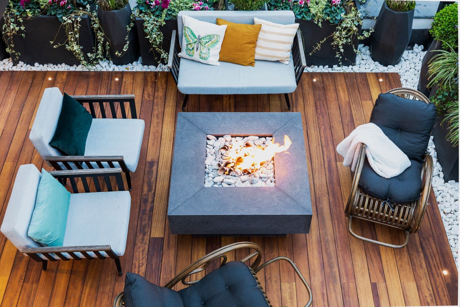 Overhead view of a wood deck with outdoor furniture and a fire table